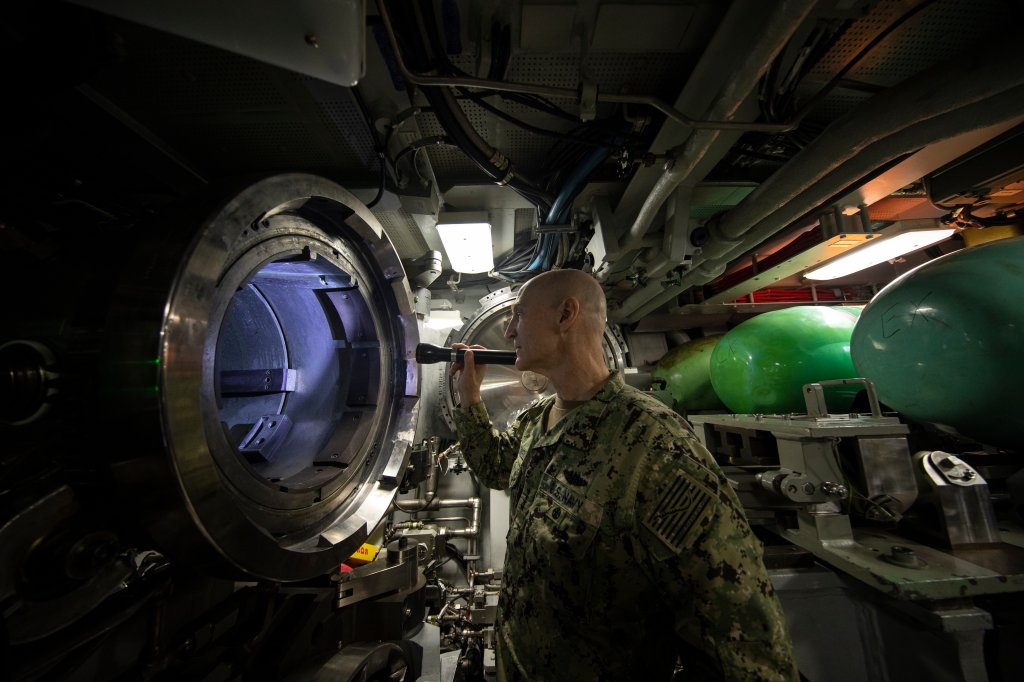 BEAUFORT SEA, Arctic Circle (March 6, 2022) – Adm. Frank Caldwell, Jr., director of the Naval Nuclear Propulsion Program, examines a torpedo tube aboard the Virginia-class fast attack submarine USS Illinois (SSN 786) during Ice Exercise (ICEX) 2022. ICEX 2022 is a three-week exercise that allows the Navy to assess its operational readiness in the Arctic, increase experience in the region, advance understanding of the Arctic environment, and continue to develop relationships with other services, allies, and partner organizations. (U.S. Navy photo by Mass Communication Specialist 1st Class Alfred Coffield/Released)