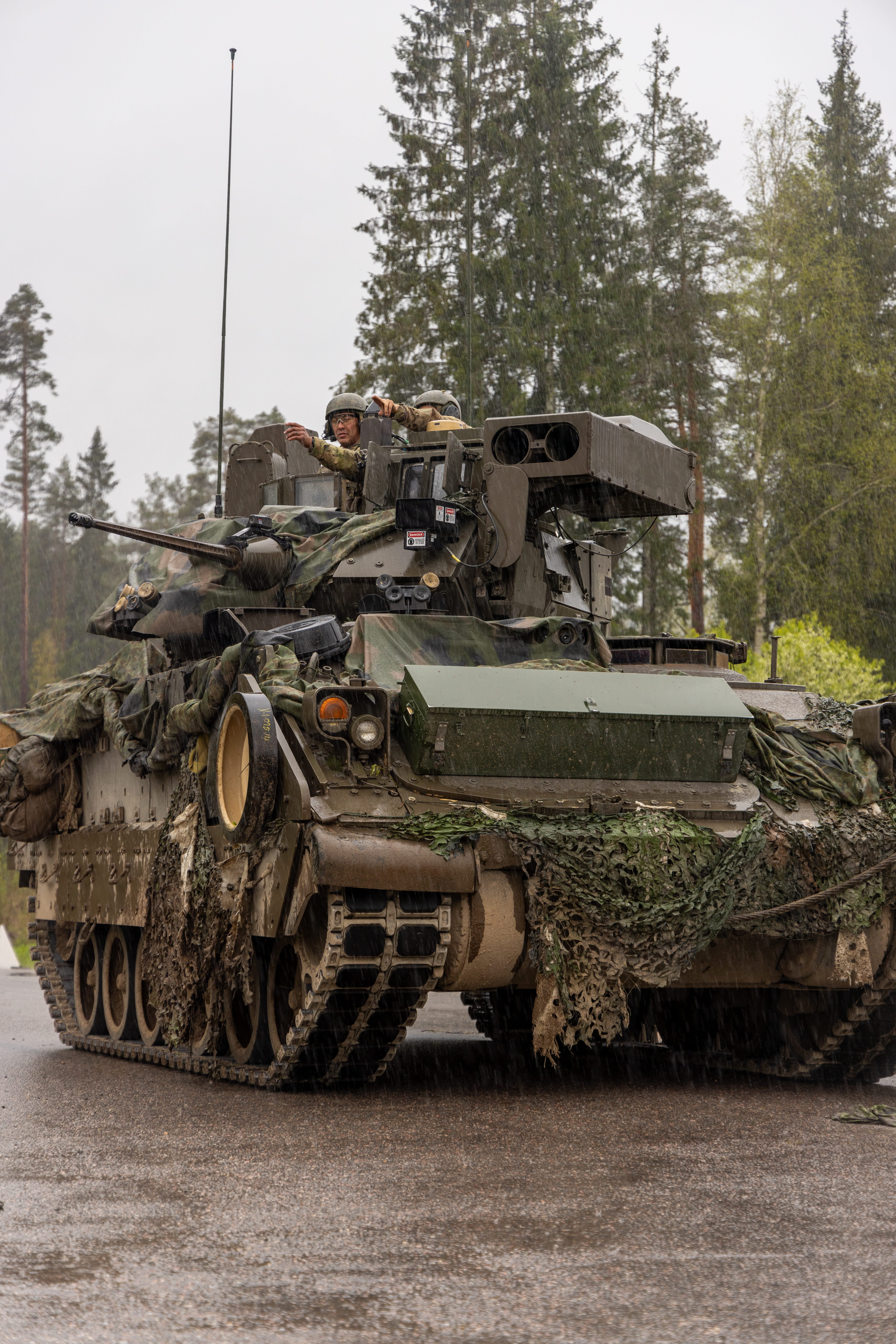 U.S. Soldiers assigned to 5th Squadron, 7th Cavalry Regiment, 1st Armored Brigade Combat Team, 3rd Infantry Division, point towards the area of their next target while in a M2A4 Bradley Fighting Vehicle during Exercise Hedgehog 25 near Camp Reedo, Estonia, May 16, 2025. Exercise Hedgehog 25 is a large-scale international military exercise led by the Estonian Defence Forces, focused on the rapid deployment of allied forces and the enhancement of multinational interoperability. As the designated opposition force, 5-7 CAV challenges participating units with a complex, realistic scenario to strengthen multinational interoperability and readiness. (U.S. Army photo by Sgt. Austin Steinborn)