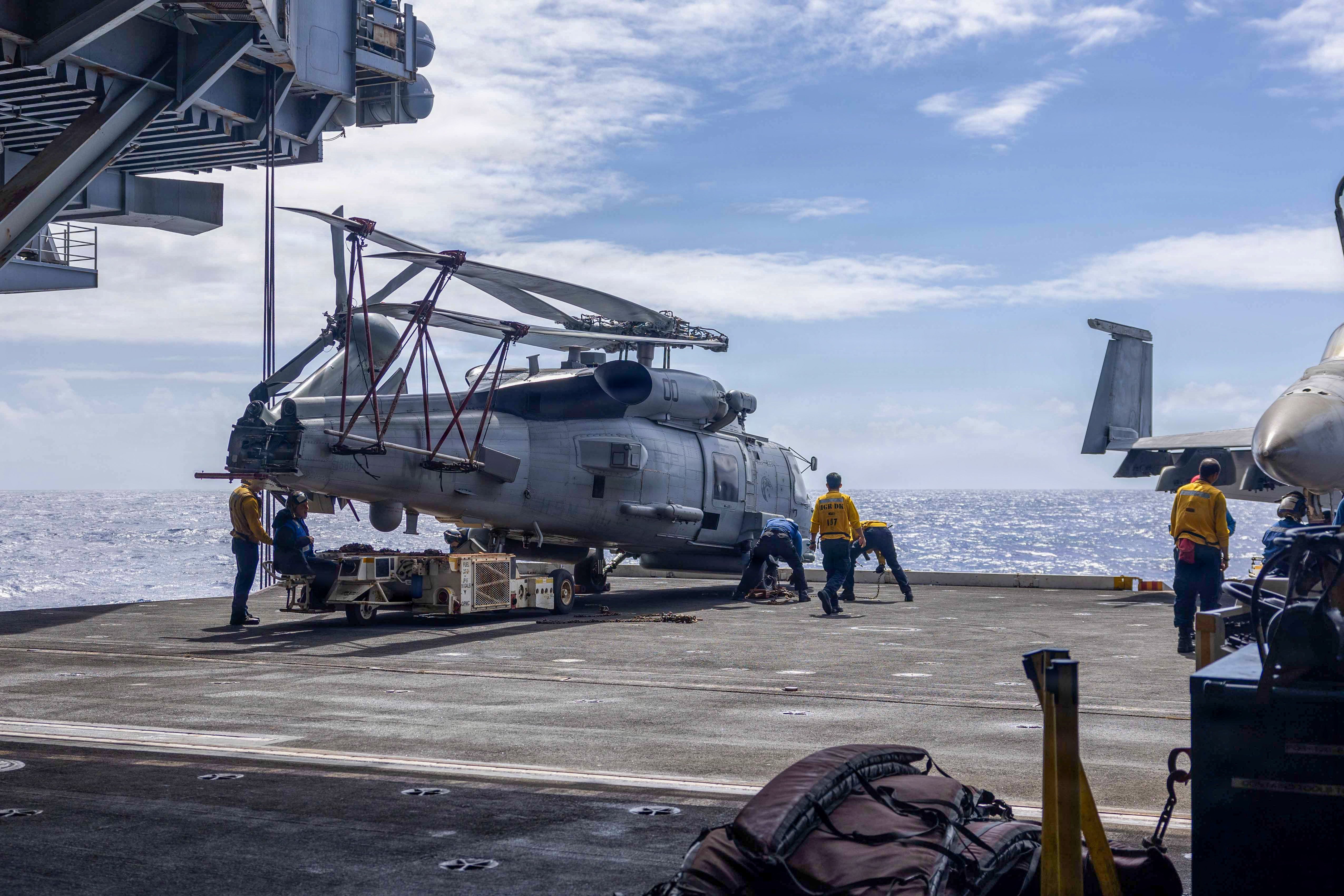 U.S. Sailors chock and chain an MH-60R Sea Hawk, assigned to Helicopter Maritime Strike Squadron (HSM) 71, aboard Nimitz-class aircraft carrier USS Abraham Lincoln (CVN 72), Sept. 28, 2026. USS Abraham Lincoln (CVN 72), flagship of the Abraham Lincoln Carrier Strike Group, is underway conducting routine operations in the U.S. 3rd Fleet area of operations, demonstrating the U.S. Navy’s long-term commitment to a free and open Indo-Pacific. (U.S. Navy photo by Mass Communication Specialist Seaman Hannah Tross)