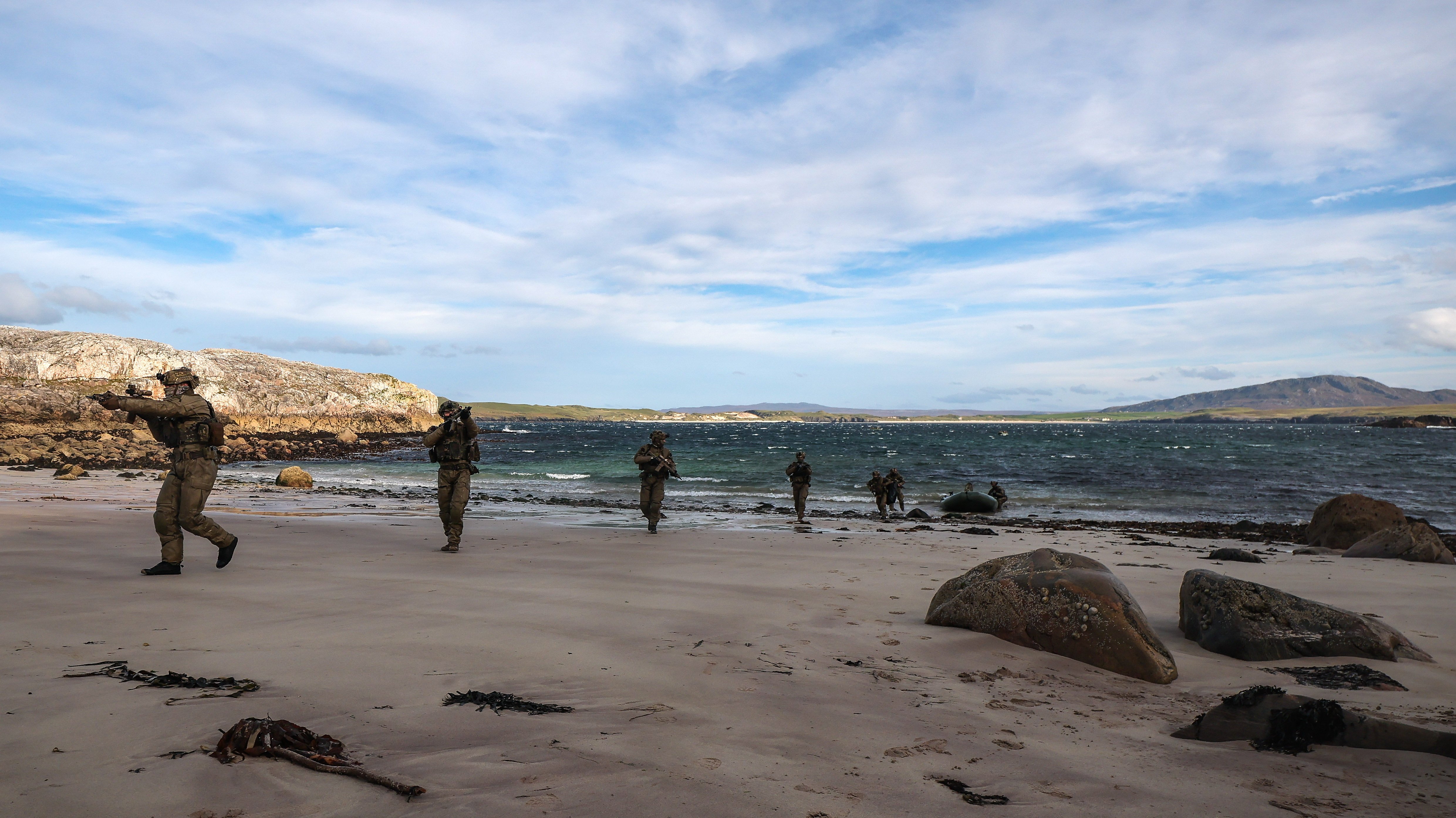29 Sep 2026 – 148 Battery secure a remote beach in Cape Wrath. 148 (Meiktila) Commando Forward Observation Battery has conducted a Full Mission Profile (FMP), integrating a German Navy submarine and Portuguese warship during Exercise Strike Warrior 26. The serial was designed to rehearse a submarine link-up and develop the Battery’s maritime integration, including float-on/float-off drills with 148’s boats. The force subsequently conducted a submarine infiltration and discreet small-boat insertion towards the target area. The FMP culminated in the establishment of an Observation Post (OP), from which the team coordinated live Naval Surface Fires from the Portuguese warship, resulting in a successful engagement and extraction. The serial demonstrated the capability of NATO partners to integrate specialist assets and coordinate complex activity across the maritime and land domains. The submarine provided Intelligence, Surveillance and Reconnaissance (ISR) support to identify and develop the target, before deploying Special Observation Teams to conduct a tactical beach landing and establish a hasty OP. The Portuguese warship subsequently delivered live Naval Surface Fires against the designated target. “This level of complexity and coordination of live assets has not been achieved by 148 for nearly 30 years. We wanted to demonstrate to our partners across the United Kingdom Commando Force, wider UK Defence and NATO SOF community the type of missions we are prepared to execute against future threats. Warfighting is our focus, and we are prepared to employ specialist assets to deliver Multi-Domain Fires and Targeting.” - Operations Officer, 148 (Meiktila) Commando Forward Observation Battery, Royal Artillery. The UK Commando Force are taking part in their largest collective workout in 15 years to demonstrate their ability to safeguard the country – and its allies – against a myriad of threats.