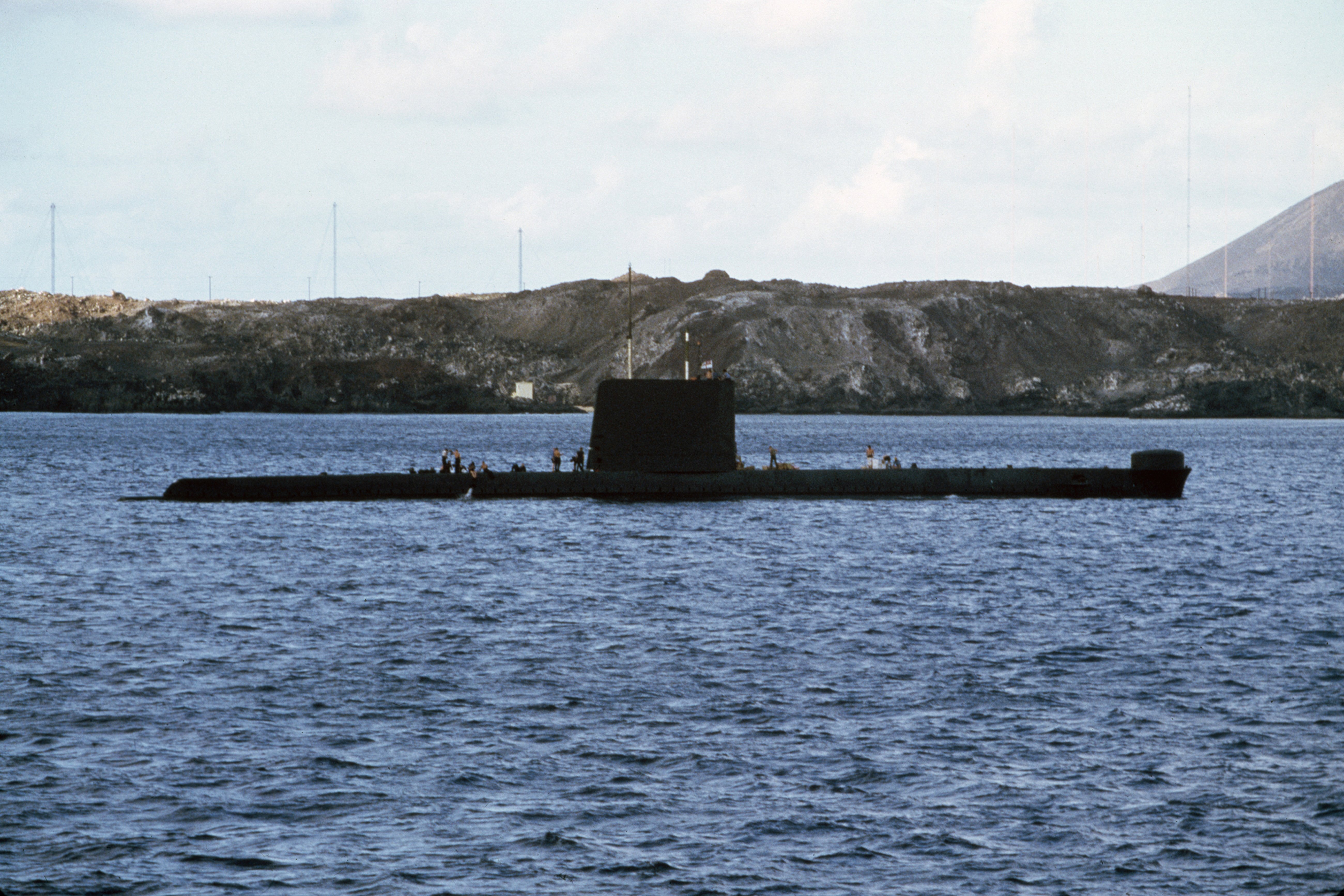 The Falklands Conflict, April - June 1982, The Oberon class submarine HMS ONYX on the surface off Ascension Island. HMS ONYX was the only diesel electric British submarine to serve in the conflict and her ability to operate silently close inshore enabled her to play an important role. In addition to providing a submarine deterrent and enforcing the exclusion zone surrounding the Islands, ONYX undertook reconnaissance, taking periscope photographs of enemy installations and likely landing areas for Special Forces operations. At Ascension Island, ONYX boarded SAS and SBS special forces personnel and supported them during a series of operations, 12 May 1982. (Photo by Dr S J Townsend/ Crown Copyright. Imperial War Museums via Getty Images)