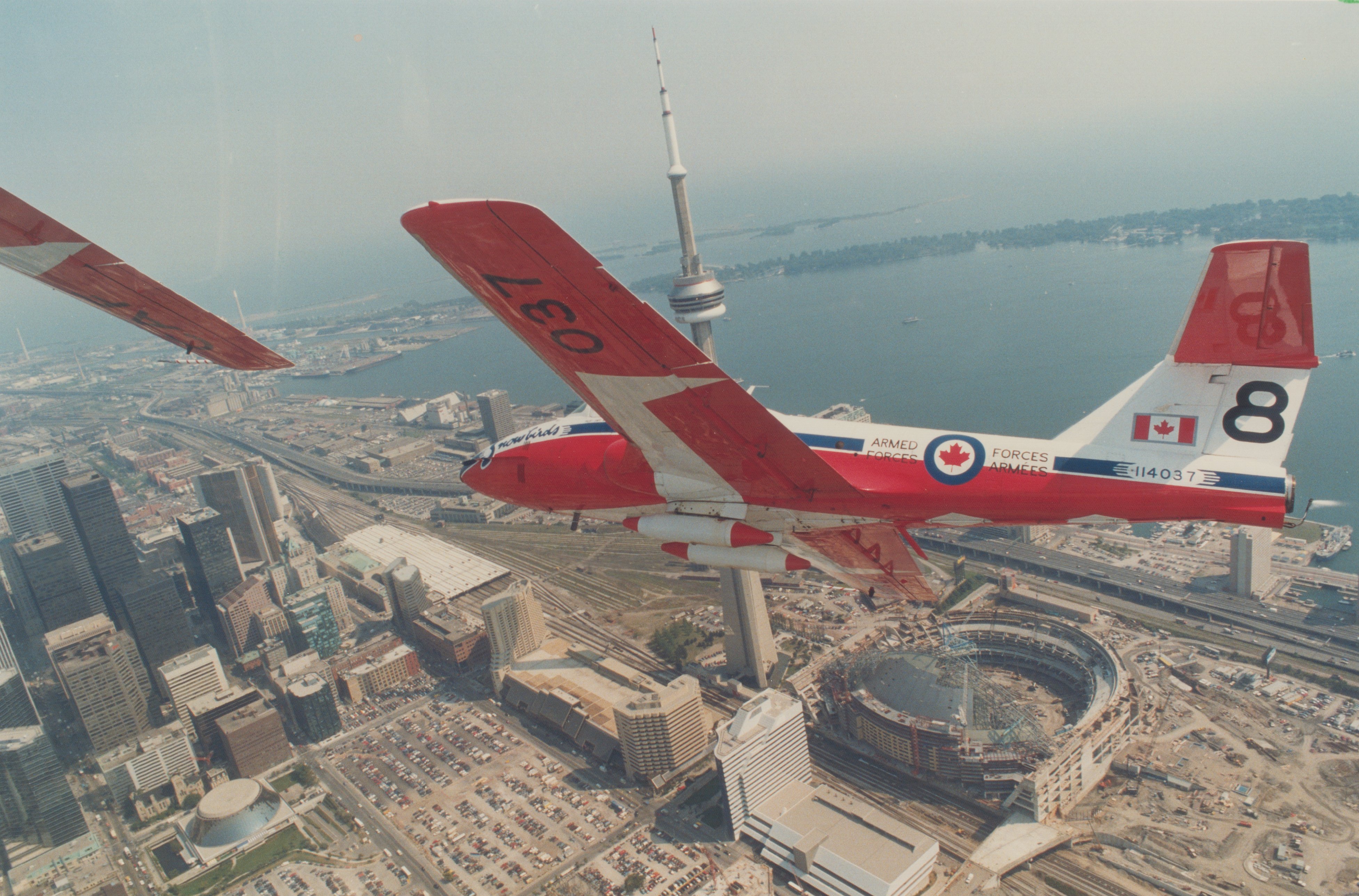 CANADA - SEPTEMBER 01: Snowbirds roar over metro. Capt. Wes MacKay banks his Canadian Forces Tutor jet over downtown Toronto yesterday in a practice run before he and fellow Snowbirds perform today at the CNE. Canada's crack aerobatics team will make no changes in their thrilling performance despite Sunday's West German air show crash that killed 49 and injured 500. (Photo by Boris Spremo/Toronto Star via Getty Images)