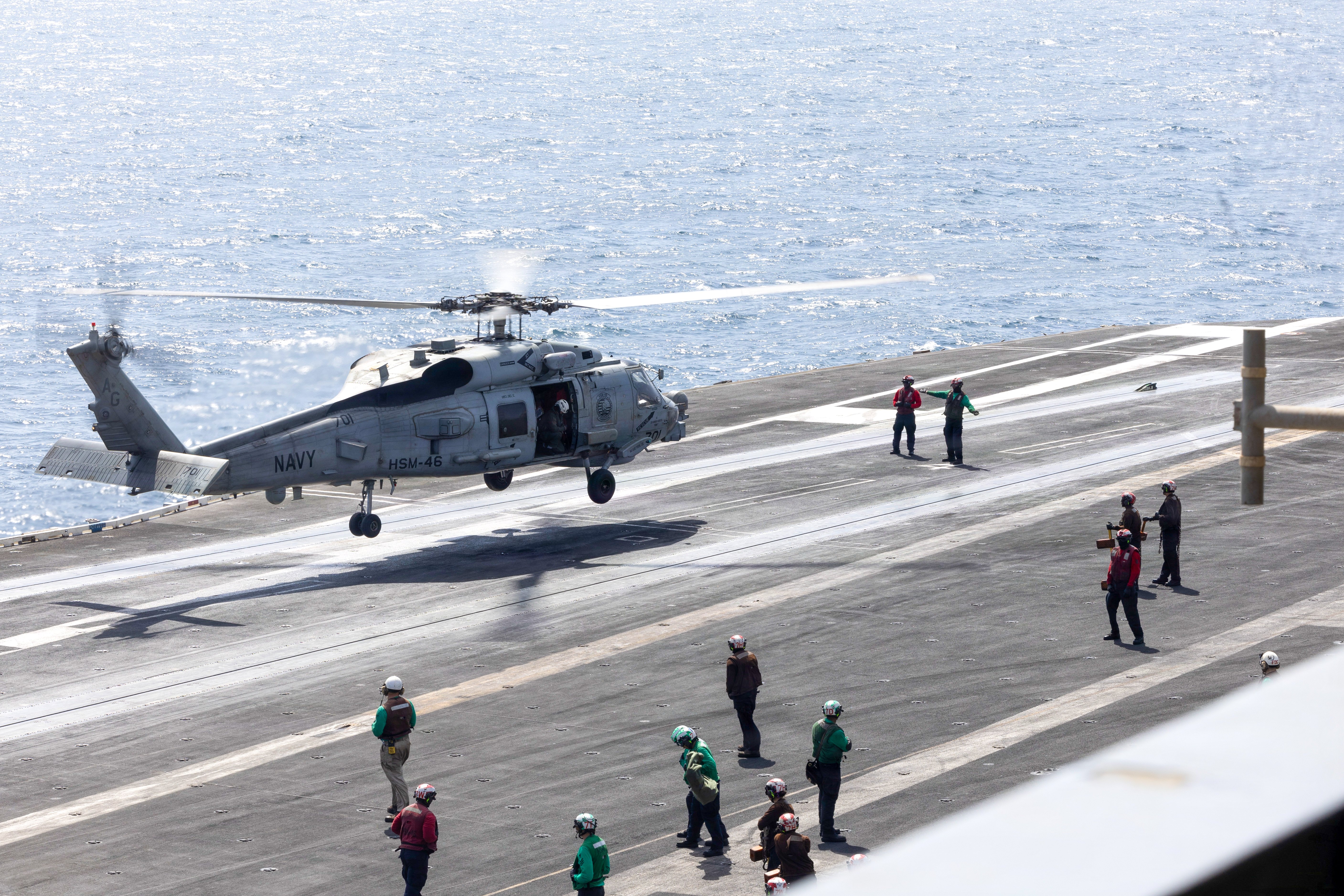 U.S. Sailors signal an MH-60R Sea Hawk attached to Helicopter Maritime Strike Squadron (HSM) 46 to land aboard Nimitz-class aircraft carrier USS George H.W. Bush (CVN 77), Sept. 27, 2026. George H.W. Bush is deployed to the U.S. 5th Fleet area of operations to support maritime security and stability in the Middle East. (U.S. Navy photo)