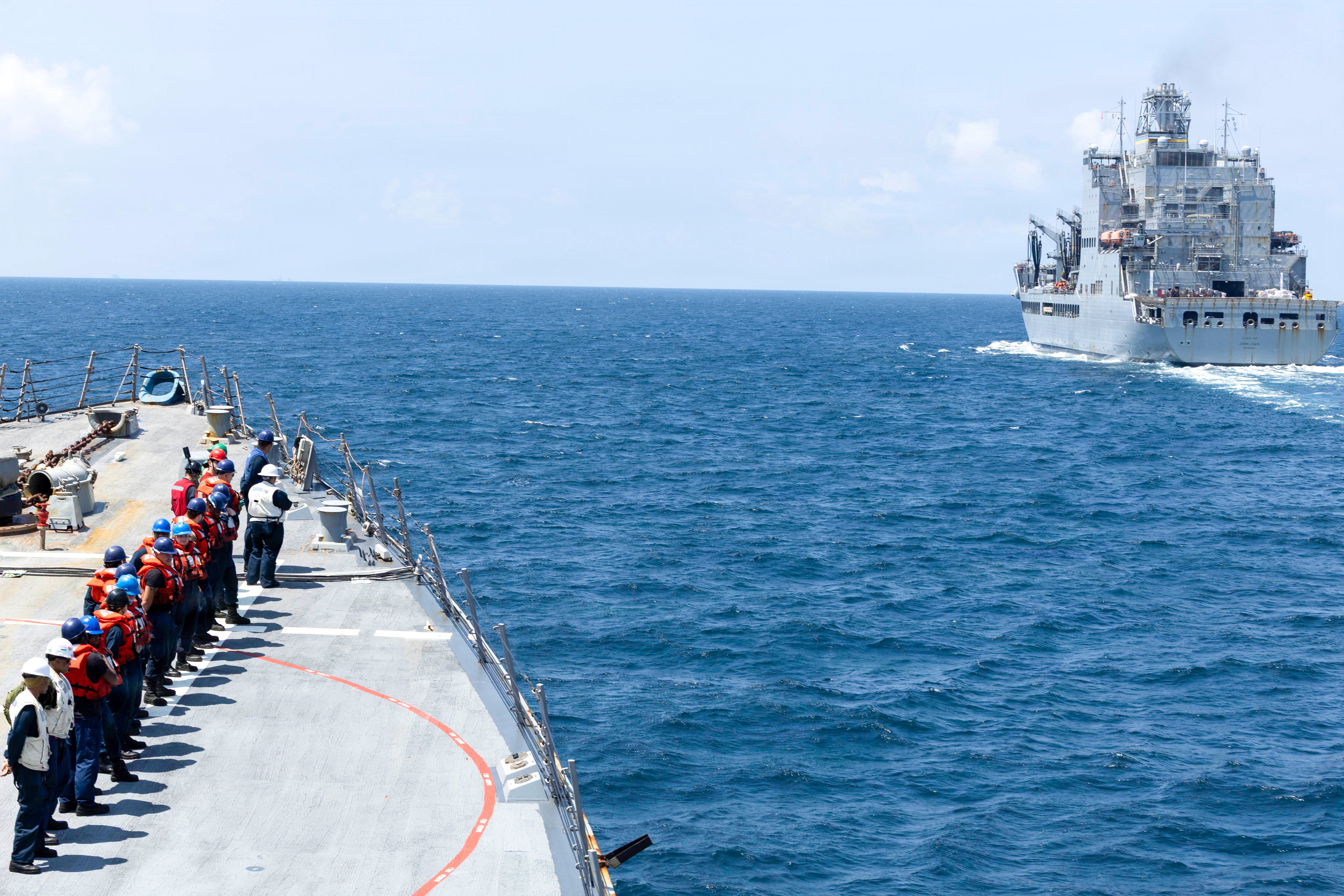 U.S. Sailors man the rails aboard Arleigh Burke-class guided-missile destroyer USS Delbert D. Black (DDG 119) during a replenishment-at-sea with fleet replenishment oiler USNS John Lewis (T-AO 205), Sept. 24, 2026. Delbert D. Black is deployed to the U.S. 5th Fleet area of operations to support maritime security and stability in the Middle East. (U.S. Navy photo)