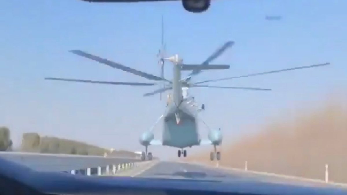 观看这架中国Z-8海军直升机沿着高速公路低空飞行